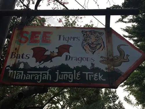 Sign for Maharajah Jungle Trek featuring images of tigers, bats, and dragons.