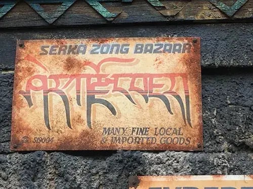 Rustic sign reading 'Serka Zong Bazaar' with translated text